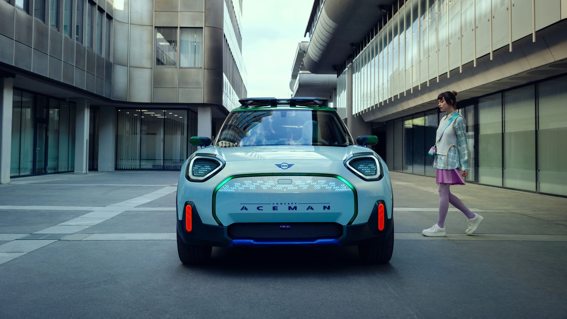 MINI Concept Aceman Imagem frontal do novo MINI Concept Aceman, enquanto mulher se encaminha para entrar nele.